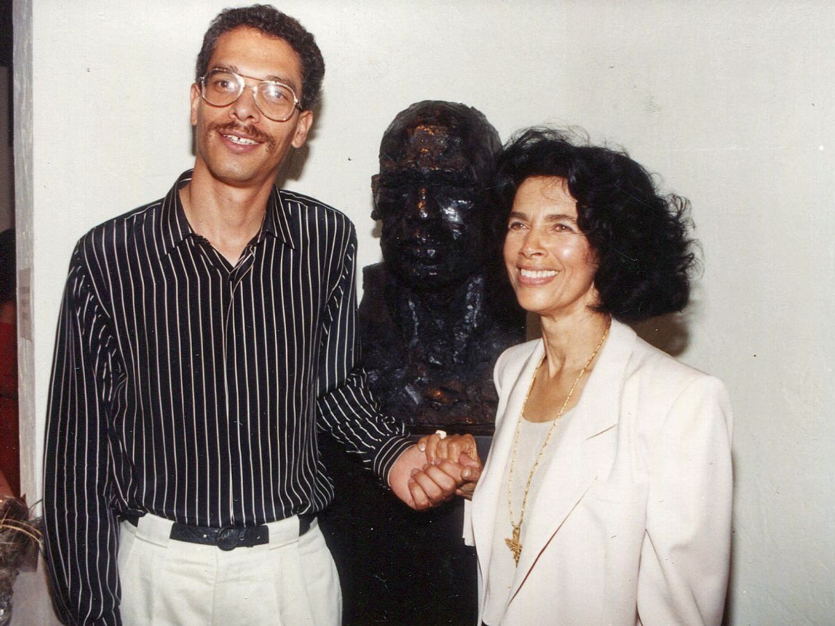 A man and woman standing next to a statue.