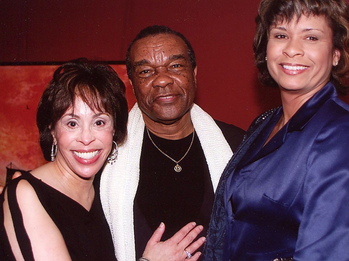 A man and two women posing for the camera.