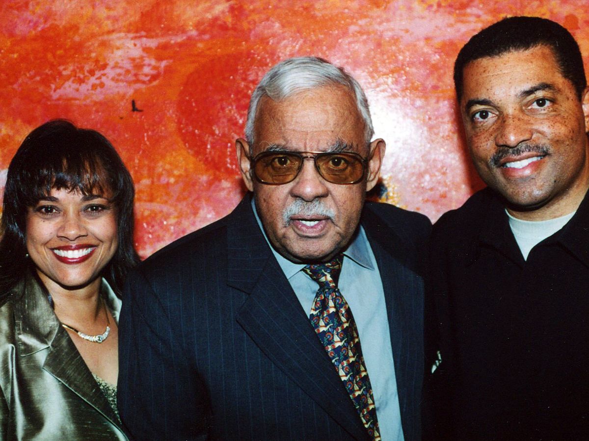 A man and two women posing for the camera.