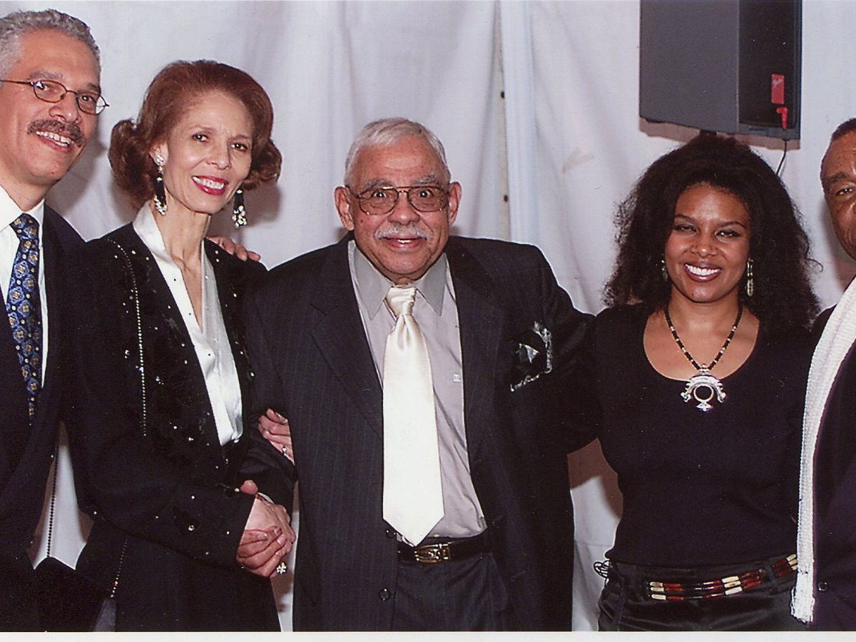A man and two women posing for the camera.