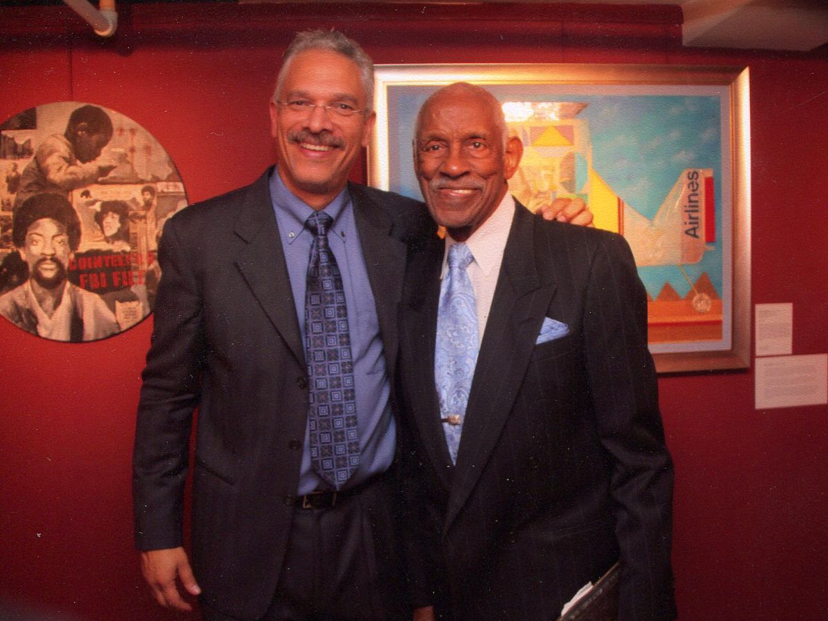 Two men in suits posing for a picture.