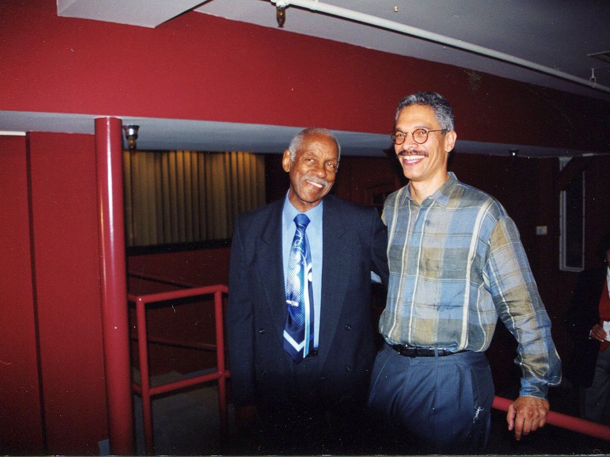 Two men standing next to each other in a room.