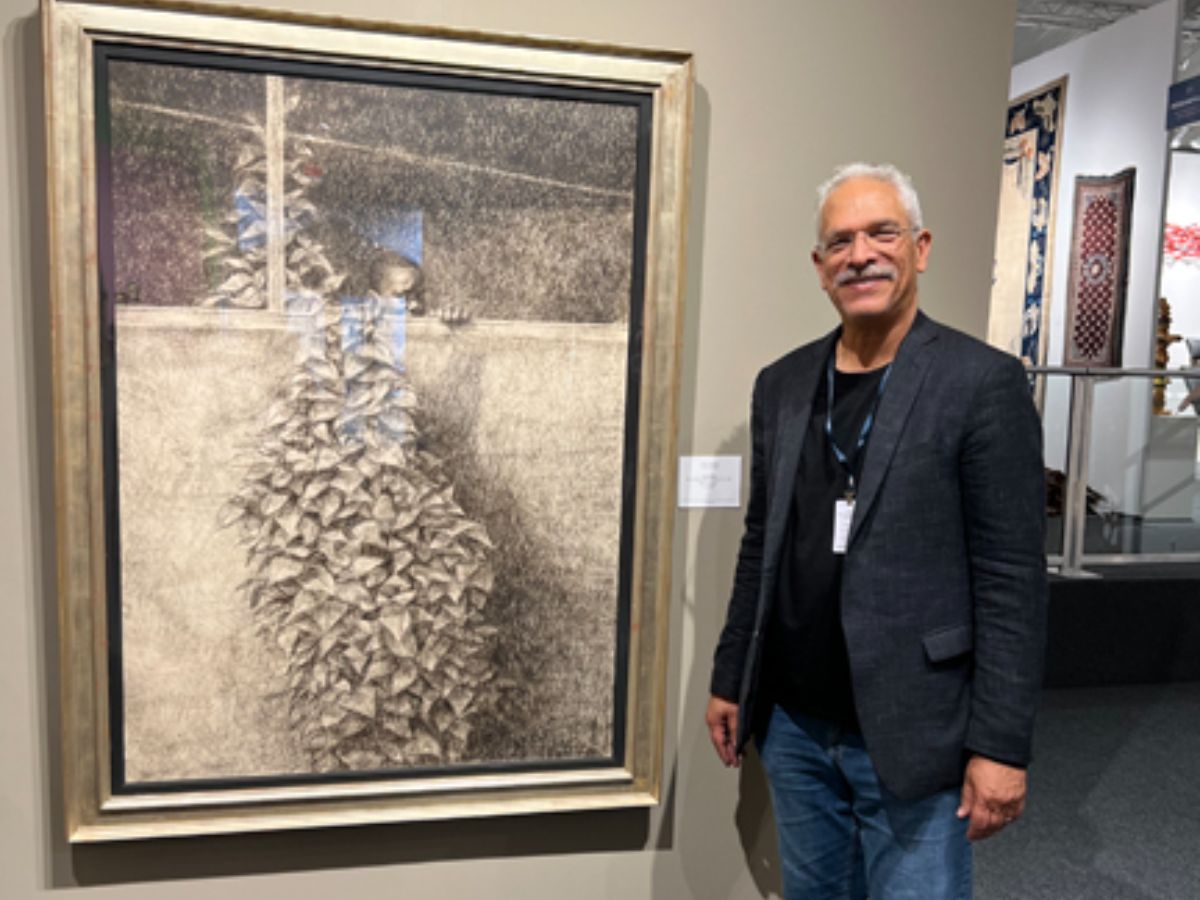 A man standing next to a painting of birds.